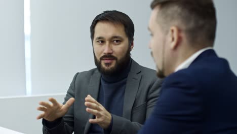 asian entrepreneur explaining business details to male coworker