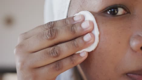 Close-up-of-african-american-plus-size-woman-using-cotton-pad,-unaltered,-slow-motion