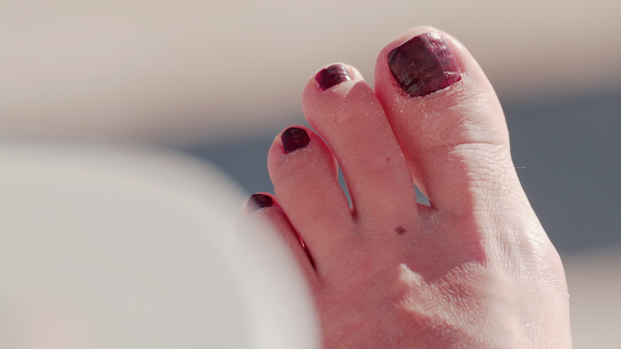 Close up of a sandy foot resting on a sunny beach in Cannes, France