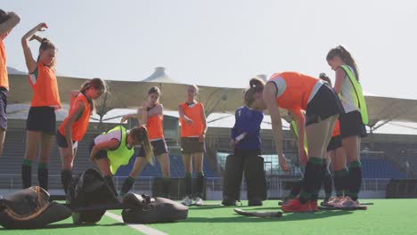 Female-hockey-players-exercising-on-the-field