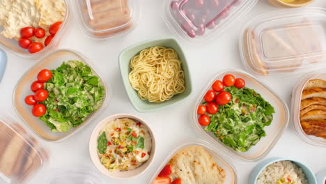 variety of healthy meal prep containers on white background