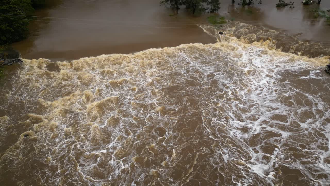 Coomera, Gold Coast, 2 January 2024 - Top down aerial view of Coomera River Causeway under flood waters from the 2024 Storms in January