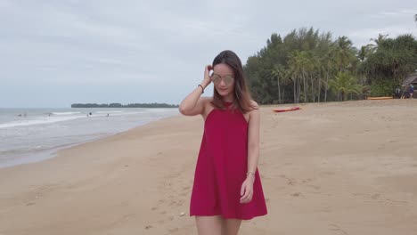 young asian woman wear red dress and walking relaxing on the beach at summer vacation holidays in slowmotion