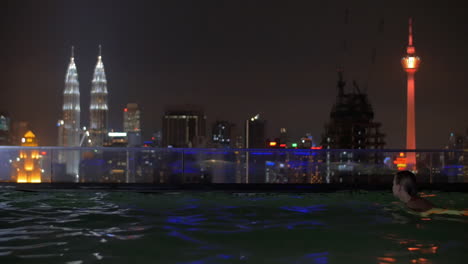 in pool on roof of a hotel in kuala lumpur malaysia is swimming young girl