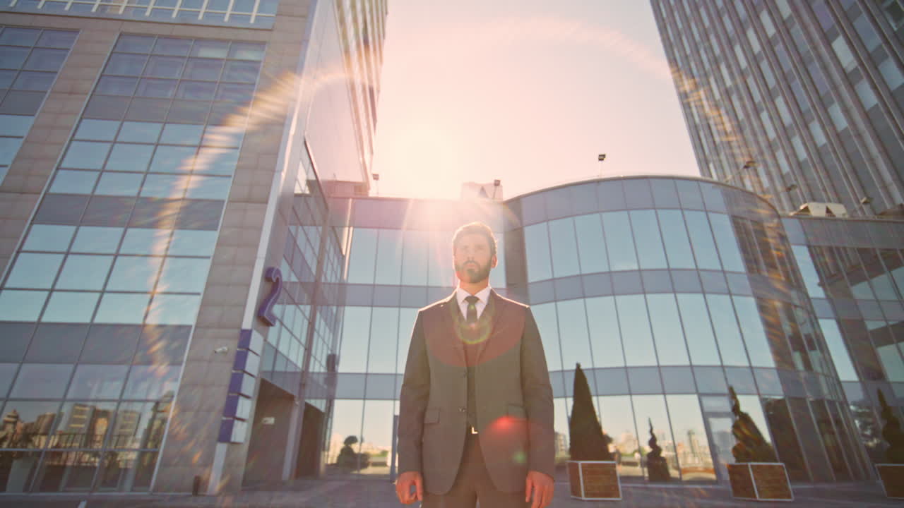 여름의 빛에 길거리에서 서 있는 잘생긴 보스. 부유한 사업가 포즈.