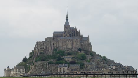 slow motion zoom out shot of mount saint michelle at a cloudy day