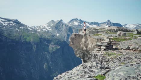 hombre caminando hacia un acantilado rocoso en las montañas katthammaren en noruega - plano general