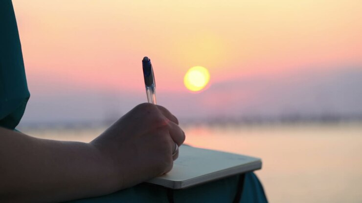Donna che scrive nel suo diario al tramonto