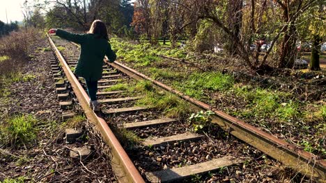 young girl walking on a single rail track towards the infinite