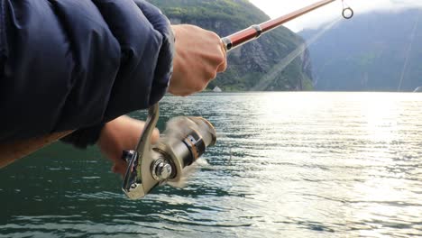 mujer pescando en una caña de pescar girando en noruega.