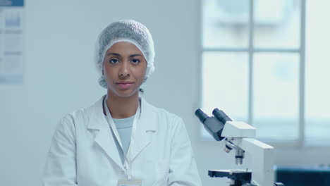 portrait of african-american female scientist with microscope in laboratory