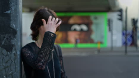retrato de moda al aire libre de una mujer joven de estilo alternativo de pie en la calle de la ciudad de londres, reino unido, con una carretera concurrida en el fondo 1