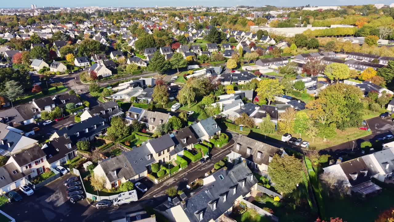 Drone aerial view of Cesson-Sévigné suburban houses with gardens and tree-lined streets in autumn, Ille-et-Vilaine, Brittany, France