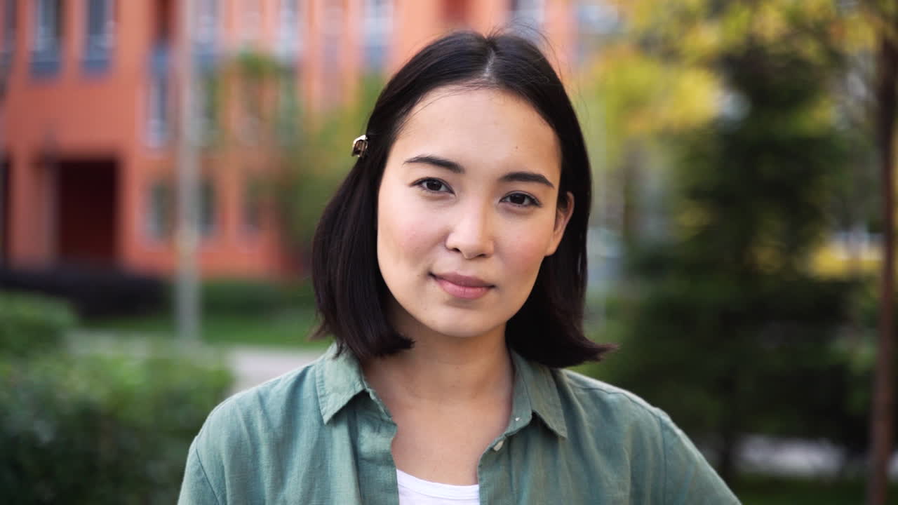 Free stock video - Outdoor portrait of a beautiful japanese girl looking and smiling at camera 2