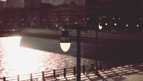 a street light overlooking a city river at sunset