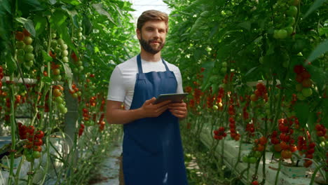 Agrónomo-Comprobando-El-Proceso-De-Cultivo-De-Tomate-En-Tableta-En-Invernadero-Innovador