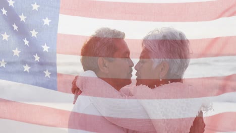 Animation-of-flag-of-united-states-of-america-over-senior-biracial-couple-embracing-on-beach