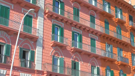 Toma-En-ángulo-Bajo-Del-Antiguo-Edificio-Histórico-De-Color-Rojo-En-El-Distrito-De-Chiaia-En-Nápoles,-Italia-En-Un-Día-Soleado