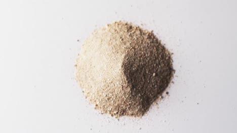 video of close up of heap of sand grains and copy space on white background