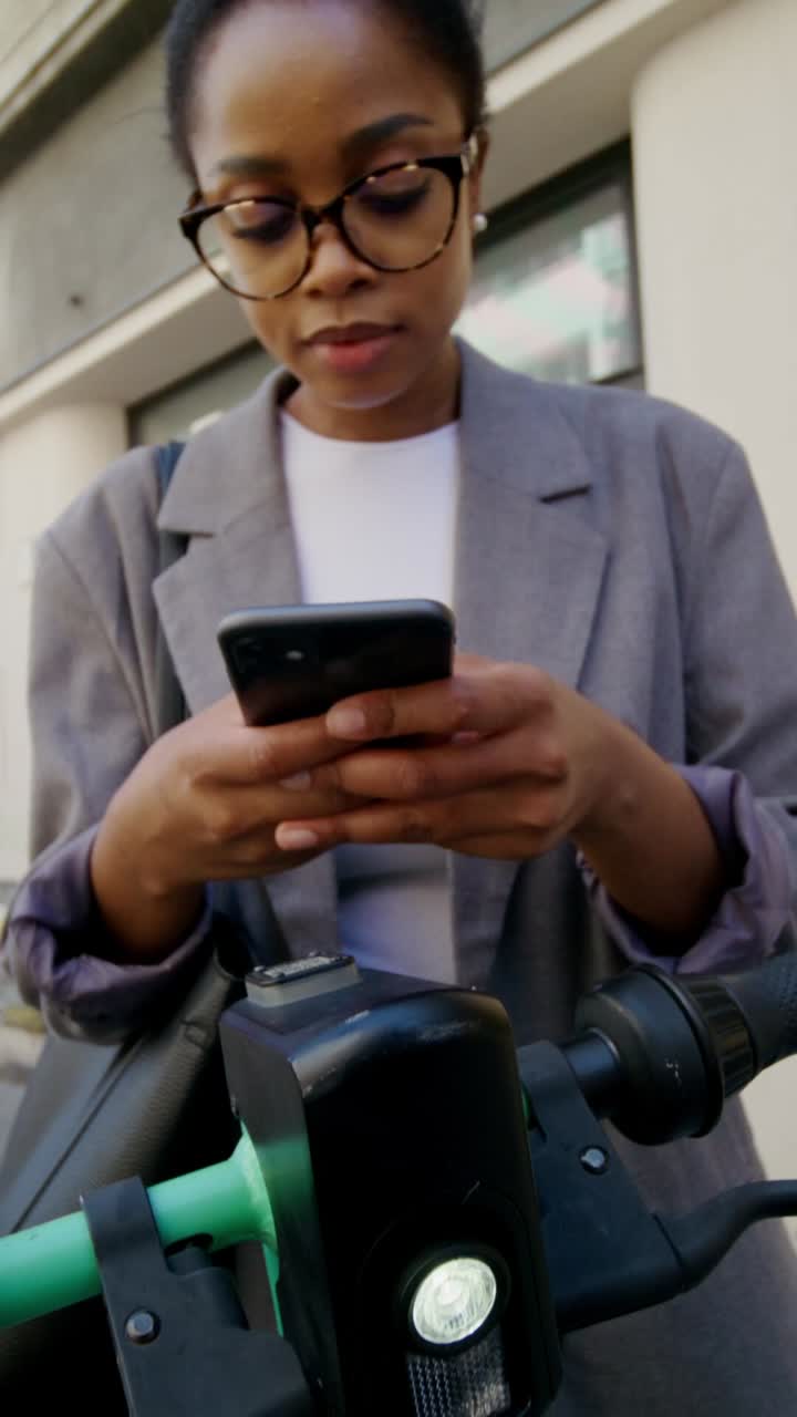 mujer de negocios usando teléfono inteligente cerca de scooter eléctrico