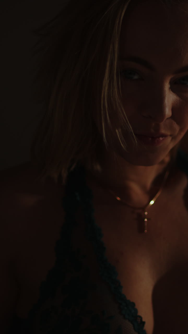 Stunning vertical portrait of an attractive blonde woman wearing an enticing bra looking at the camera
