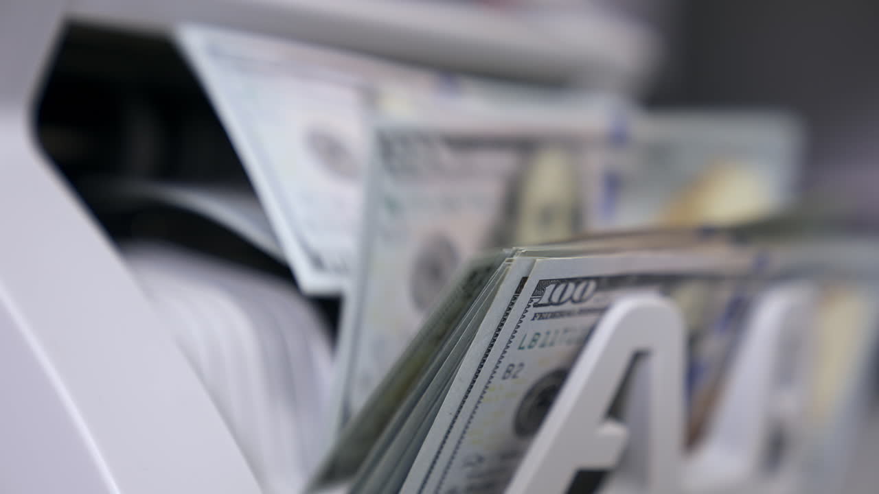 Close Up money counting machine. A bunch of american Banknotes. The world currency is the US dollar.