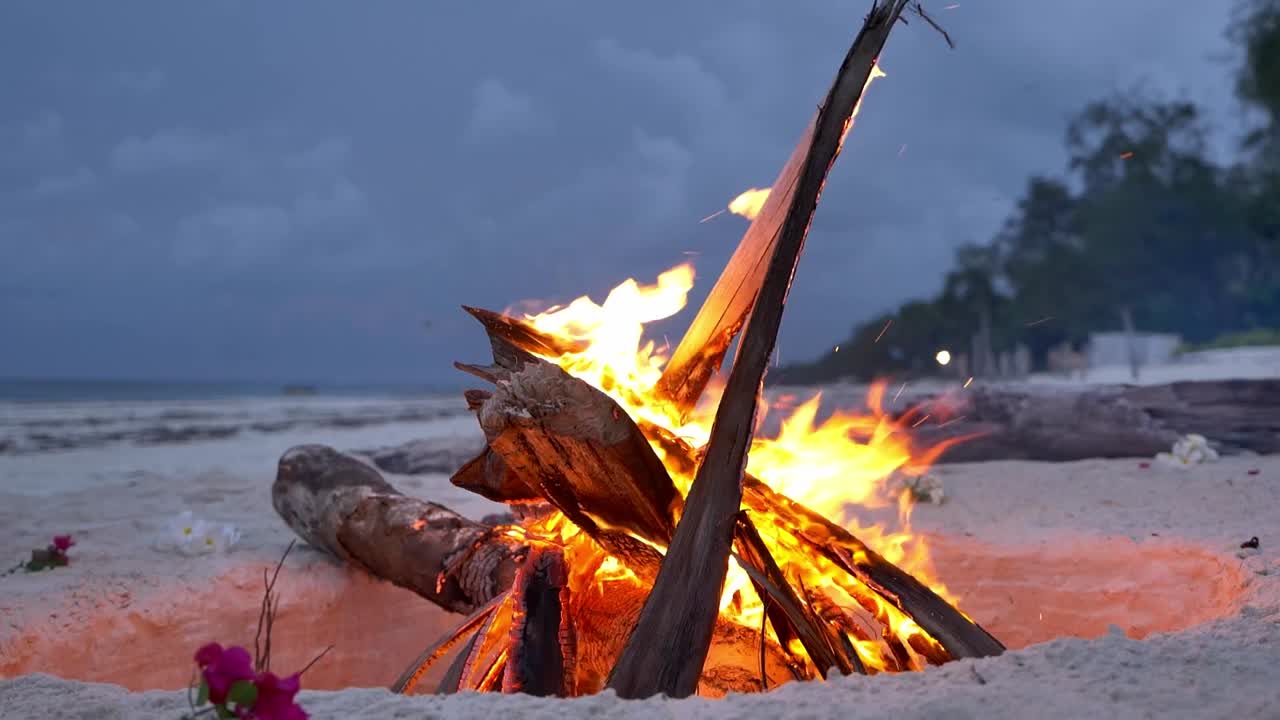 toma de tierra de un montón de hogueras dentro de un hoyo en la playa de arena, camping