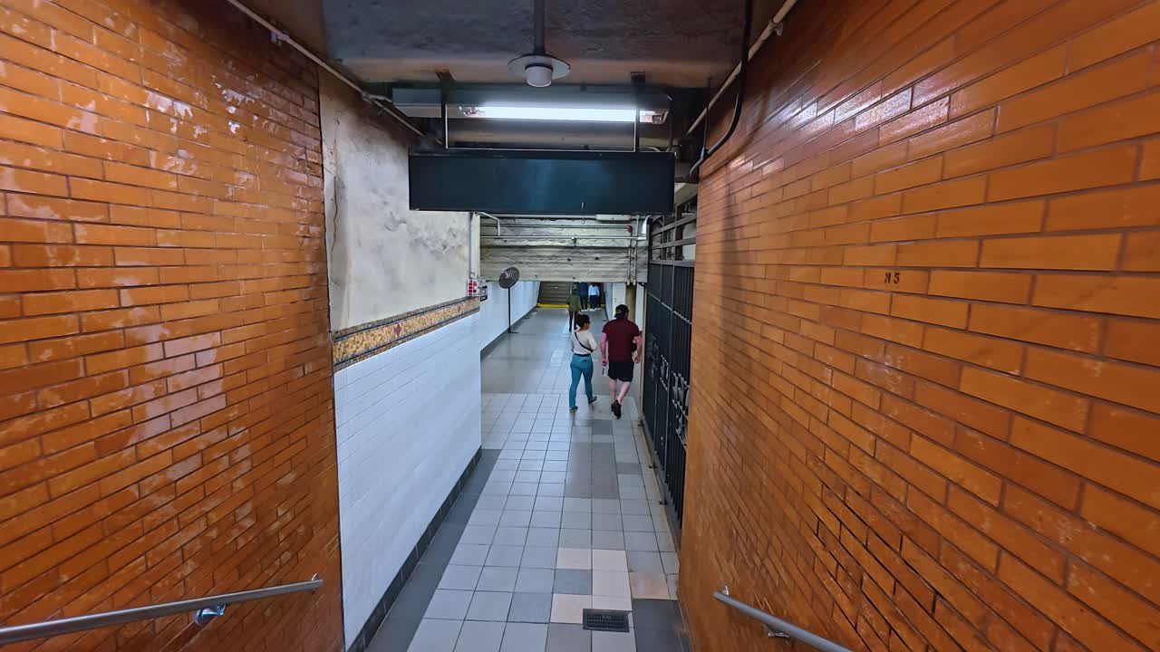 New York, USA, 7 agosto 2025: Tunnel d'ingresso della metropolitana di New York con piastrelle arancioni. Vista interna di un tunnel pedonale che conduce a una stazione della metropolitana di New York, caratterizzato da pareti in piastrelle di mattoni arancioni.