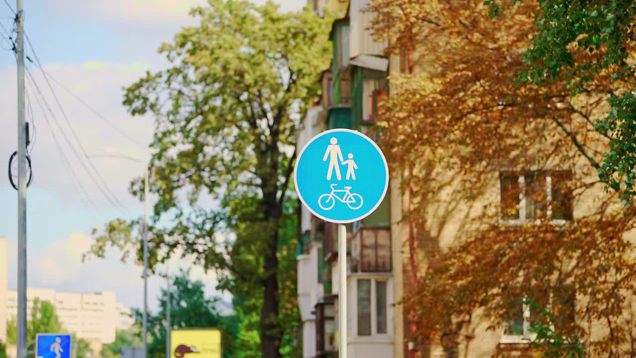 오렌지색과 초록색의 나무를 배경으로 한 파란색 표지판, 가을 공원, 자전거 표지판.