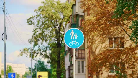 blue sign on a background of orange and green trees. autumn park. bicycle sign.