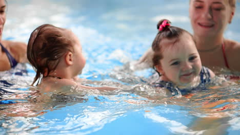 Grupo-De-Mamás-Con-Sus-Bebés-En-La-Clase-De-Natación-Infantil.