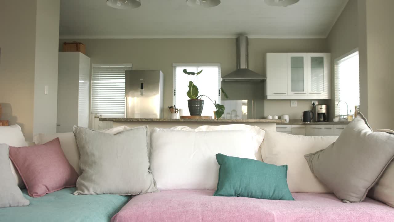 vista general de la sala de estar con un cómodo sofá y cocina en el fondo, cámara lenta