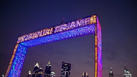 dubai frame illuminating with vibrant led lights after dark, featuring glowing skyscrapers surrounding landmark architectural attraction in zabeel park, dubai cityscape, united arab emirates