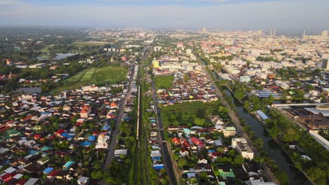 aerial shot: a freight train crossing through the town in thailand, asia