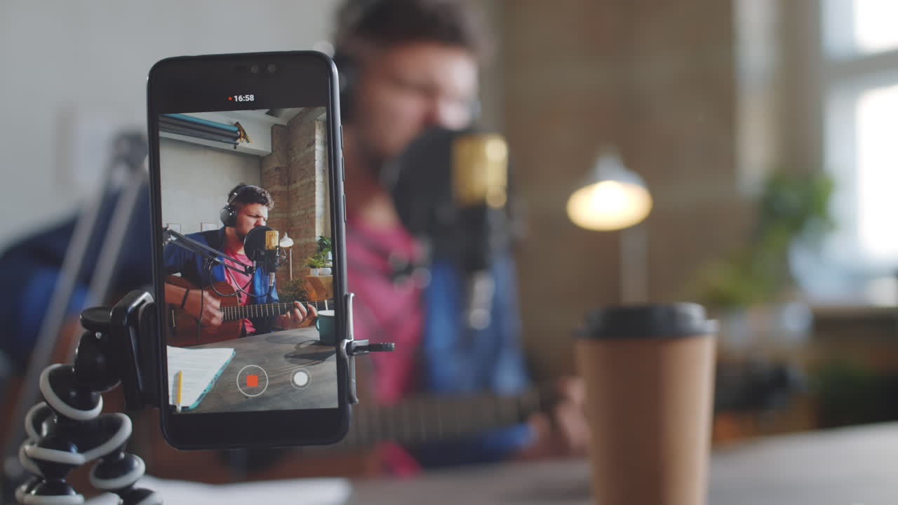 smartphone filmando el concierto en línea de un cantante masculino