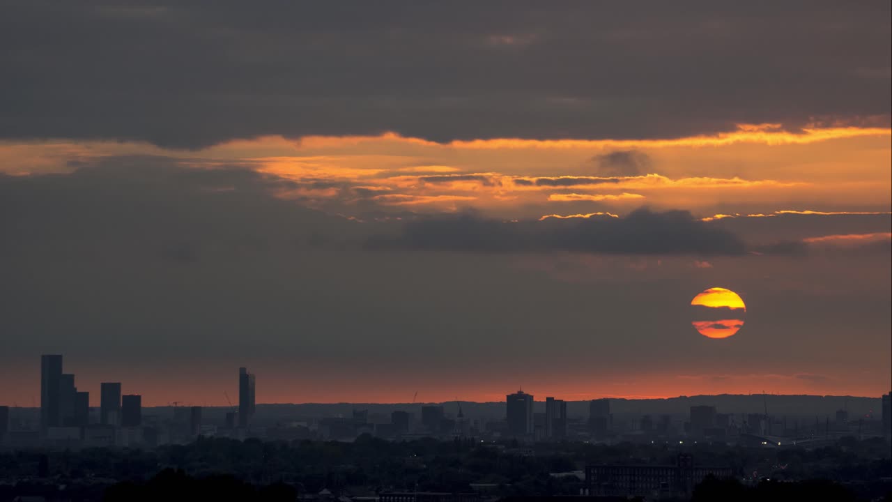 Sunset over manchester with a huge orange sun setting behind the CBD.