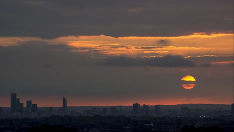 sunset over manchester with a huge orange sun setting behind the cbd.