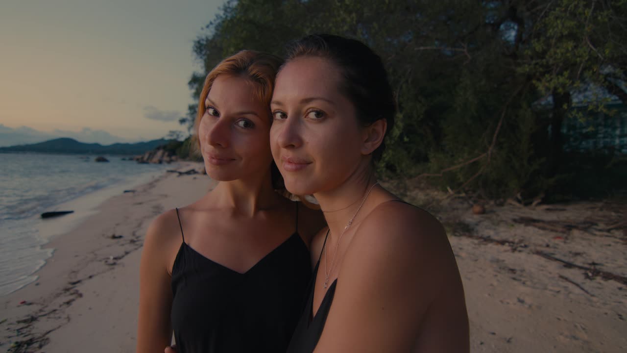 To kvinder på en strand ved solnedgang