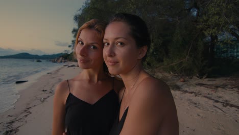 two women on a beach at sunset