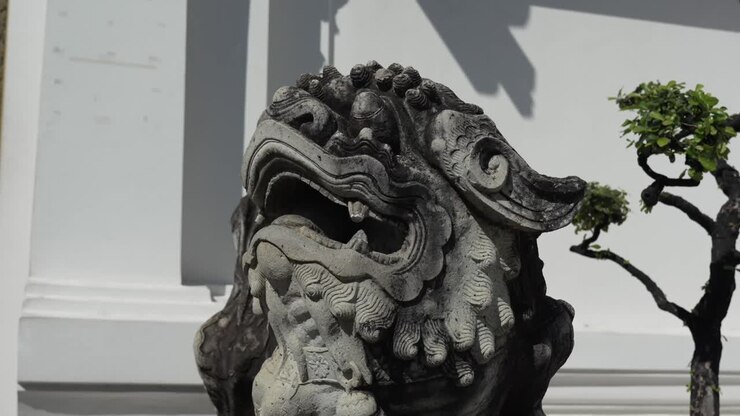 Statua di un antico guardiano in pietra al Wat Pho, Bangkok, Thailandia, che rappresenta l'arte tradizionale thailandese e il simbolismo spirituale all'interno del complesso del tempio