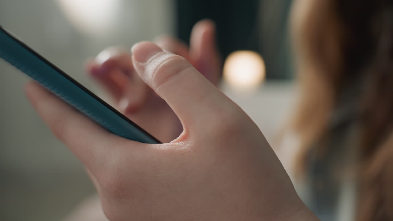 Nærbilde av kaukasisk hånd som trykker på smarttelefon, detalj av fingertupp med stearinlys-bokeh, intim kveldsstemning, mykt varmt lys, bevisst rullebevegelse, subtil skjermglød på huden, beroligende stille scene