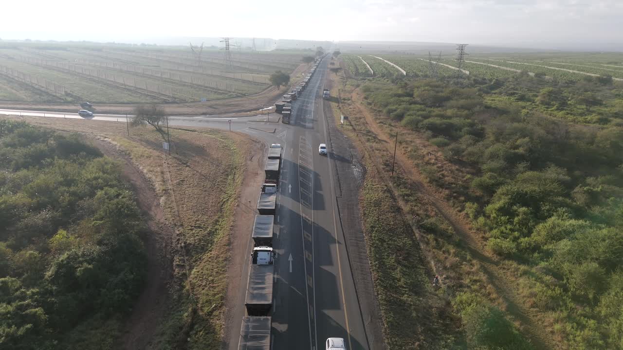 descenso cinematográfico de drones en un gran número de camiones de carga atrapados en una larga cola en una autopista antes de un puesto fronterizo
