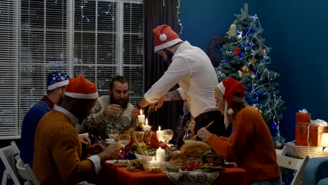 amigos riendo teniendo pavo asado en la cena de navidad