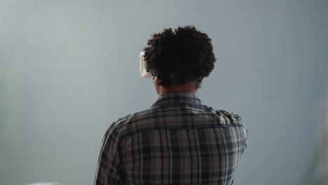 hombre afroamericano con auriculares vr desliza objetos invisibles