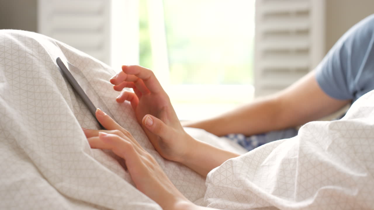 침대에서 태블릿을 사용하는 커플