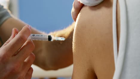 Physiotherapist-injecting-female-patient