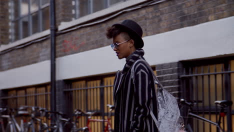 un elegante bloguero de moda de pie en una calle urbana