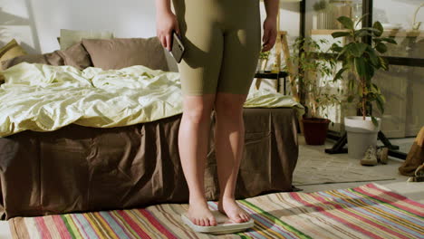 young woman with smartphone on her bedroom