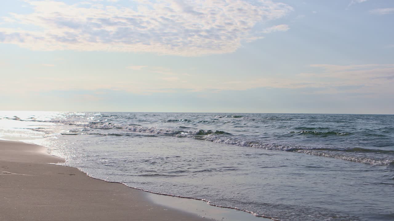 한 여성이 해가 질 때 바다에서 해변으로 달려간다