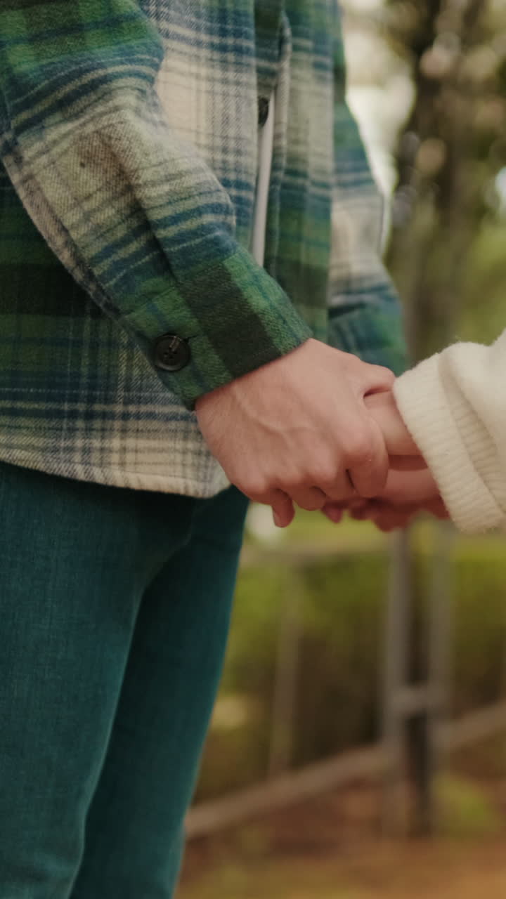 Close-up of young couple holding hands